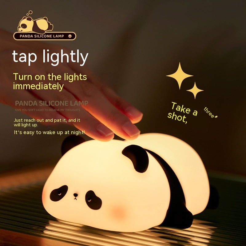 Panda silicone lamp being tapped by a hand on a dark background