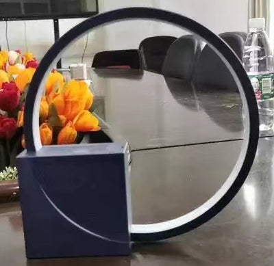 Modern circular mirror with a blue base on a reflective surface