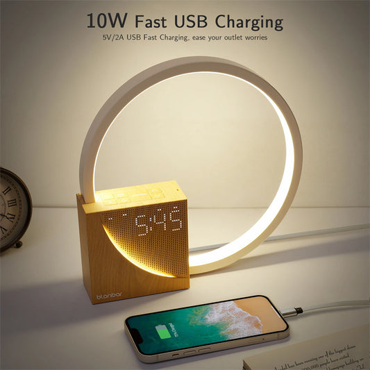 Smart clock with LED display and circular light feature on a table.