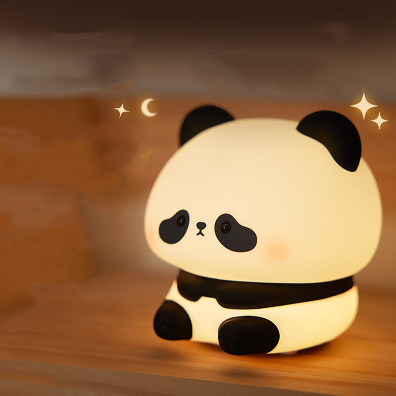 Panda-shaped night light on a wooden surface with a warm glow